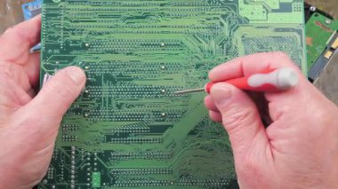 Atölyedeki ana kartı tamir et. Ustanın elleri, kullanım sürecindeki arızalar nedeniyle elektronik aletleri tamir edecek şekilde yakın plan çekimde. Yakın plan. Yavaş çekim.