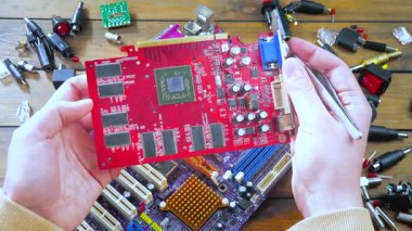 Atölyedeki ana kartı tamir et. Ustanın elleri, kullanım sürecindeki arızalar nedeniyle elektronik aletleri tamir edecek şekilde yakın plan çekimde. Yakın plan. Yavaş çekim.