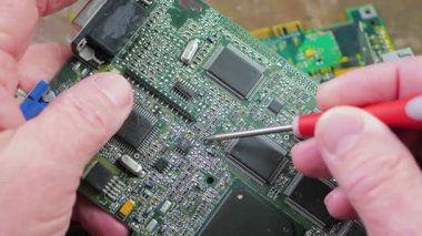 Atölyedeki ana kartı tamir et. Ustanın elleri, kullanım sürecindeki arızalar nedeniyle elektronik aletleri tamir edecek şekilde yakın plan çekimde. Yakın plan. Yavaş çekim.