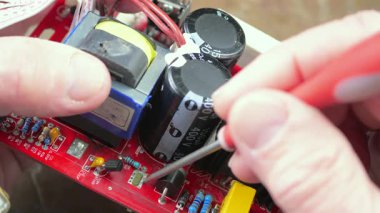 Atölyedeki ana kartı tamir et. Ustanın elleri, kullanım sürecindeki arızalar nedeniyle elektronik aletleri tamir edecek şekilde yakın plan çekimde. Yakın plan. Yavaş çekim.