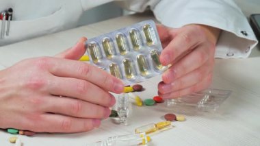 Genç bir doktor hapları muayene edip avucuna atıyor. Yakın plan. Yavaş çekim.
