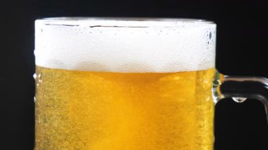 Hafif bira, köpüklü ve bira bardağında köpüklü. Yakın plan. Yavaş çekim.