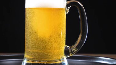 Hafif bira, köpüklü ve bira bardağında köpüklü. Yakın plan. Yavaş çekim.