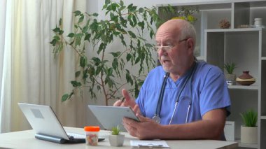 Ofisteki yaşlı bir doktor, cep telefonuyla duygusal iletişim kuruyor..