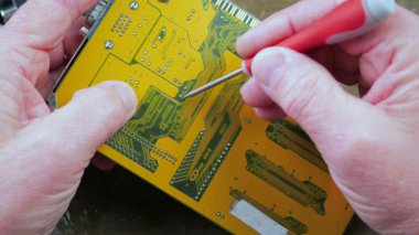 Elektronik tamirci, bilgisayarlar için elektronik panoları tamir eder ve korur. Erkek eli. Yakın plan. Yavaş çekim.