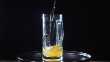 Hafif, köpüklü bira bardağa dökülür. Yavaş çekim.