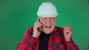 Yeşil bir geçmişi olan yaşlı bir ustabaşı telefonla konuşuyor.