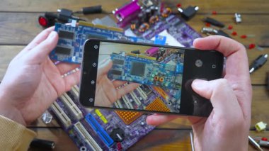 Teknisyen akıllı telefonuyla tamir edilmiş tahtanın fotoğrafını çekiyor..