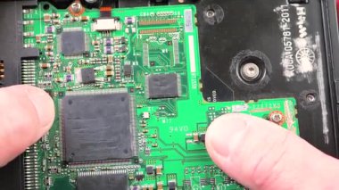 Atölyedeki ana kartı tamir et. Ustanın elleri, kullanım sürecindeki arızalar nedeniyle elektronik aletleri tamir edecek şekilde yakın plan çekimde. Yakın plan. Yavaş çekim.