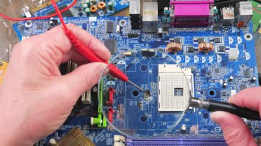 Atölyedeki ana kartı tamir et. Ustanın elleri, kullanım sürecindeki arızalar nedeniyle elektronik aletleri tamir edecek şekilde yakın plan çekimde. Yakın plan. Yavaş çekim.