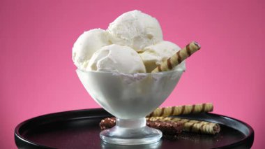 Bardaktaki dondurma, parlak renkli arka planda, yavaşça kendi ekseni etrafında döner..