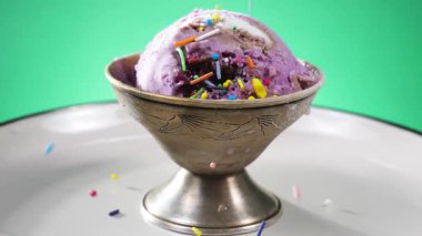 Dondurma, parlak renkli arka planda metal bir plaka içinde yavaşça kendi ekseni etrafında döner..