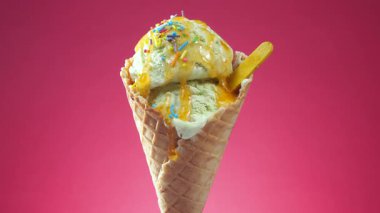 Gözleme külahında dondurma, parlak renkli bir arka plan karşı, kendi ekseni etrafında yavaşça döner.