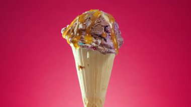 Gözleme külahında dondurma, parlak renkli bir arka plan karşı, kendi ekseni etrafında yavaşça döner.