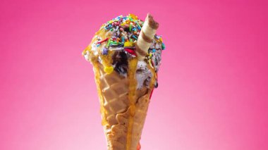 Gözleme külahında dondurma, parlak renkli bir arka plan karşı, kendi ekseni etrafında yavaşça döner.