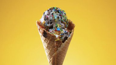 Gözleme külahında dondurma, parlak renkli bir arka plan karşı, kendi ekseni etrafında yavaşça döner.