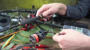 Yaşlı bir balıkçının elleri balıkçılık malzemeleri üretimi ve montajı ile meşguldür..