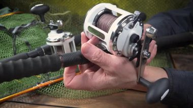 Yaşlı bir balıkçının elleri balıkçılık malzemeleri üretimi ve montajı ile meşguldür..