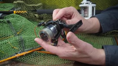 Yaşlı bir balıkçının elleri balıkçılık malzemeleri üretimi ve montajı ile meşguldür..