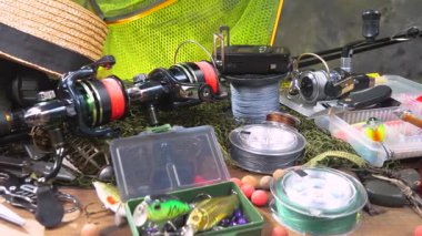 Yatay düzlem boyunca yavaşça hareket eden balıkçılık malzemeleri masanın üzerinde bir kompozisyonda düzenlenir..