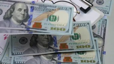 Dolar banknotları iş belgelerine dökülüyor. Yakın plan. Yavaş çekim.