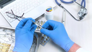 Genç bir doktor şırıngayı inceler, bir hastalığı tedavi etmek için uygulama ve eylem derecesini inceler. Yakın plan. Yavaş çekim.