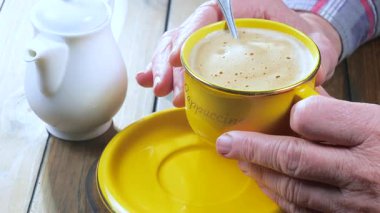 Yaşlı bir adam, bir fincan sıcak kahve ve espresso içer. Yakın plan. Yavaş çekim.