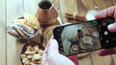 Yaşlı bir adam kahve çekirdeğinin arka planına karşı elleriyle bir fincan sıcak kahve alır. Yakın plan. Yukarıdan bak. Yavaş çekim.