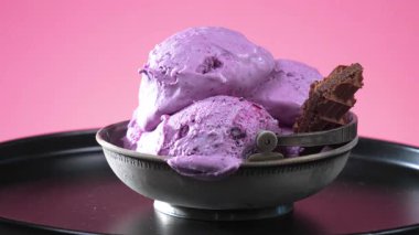 Metal kasede tatlı dondurma, dondurma kepçesiyle yavaşça çıkarılıp tatlı toplara dönüşüyor. Yakın plan. Yavaş çekim.