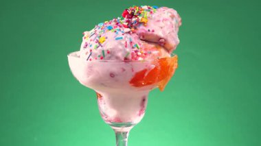 Cam bir kabın içindeki tatlı dondurma yavaşça ekseni etrafında döner. Yavaş çekim.