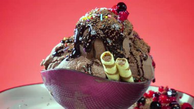 Cam bir kabın içindeki tatlı dondurma yavaşça ekseni etrafında döner. Yavaş çekim.