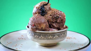 Cam bir kabın içindeki tatlı dondurma yavaşça ekseni etrafında döner. Yavaş çekim.