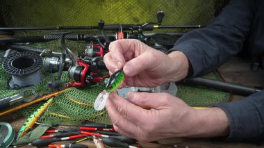 Balıkçı, kurulum ve balıkçı teçhizatı denemeleri ile meşgul. Yakın plan. Yavaş çekim.
