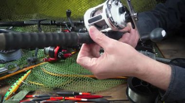 Balıkçı, kurulum ve balıkçı teçhizatı denemeleri ile meşgul. Yakın plan. Yavaş çekim.