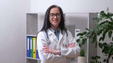 Genç doktor, doktorluk yapıyor, tıbbi ekipmanlarla çalışıyor, hastaların tıbbi geçmişlerini araştırıyor. Yavaş çekim.