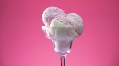 Cam bir kabın içindeki tatlı dondurma yavaşça ekseni etrafında döner. Yavaş çekim.