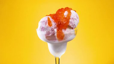 Cam bir kabın içindeki tatlı dondurma yavaşça ekseni etrafında döner. Yavaş çekim.