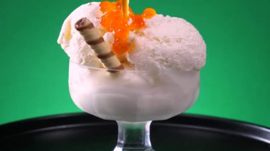 Cam bir kabın içindeki tatlı dondurma yavaşça ekseni etrafında döner. Yavaş çekim.