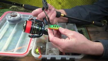 Balıkçı, kurulum ve balıkçı teçhizatı denemeleri ile meşgul. Yakın plan. Yavaş çekim.
