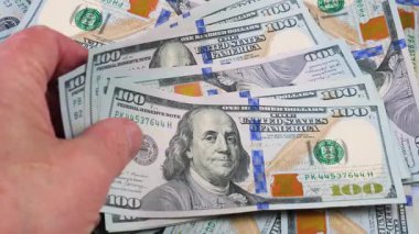 Yaşlı bir finansörün elleri yavaş yavaş para, dolar kaydırıyor. Yavaş çekim.