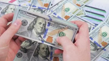Genç bir finansörün elleri yavaş yavaş para, dolar kaydırıyor. Yavaş çekim.