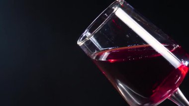 Kırmızı şarap siyah arka planda sallanıyor..