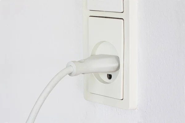 白い壁の背景の電気コンセントに接続された電気機器からのプラグの閉鎖 コードで白い電源コンセント 電力の概念 — ストック写真