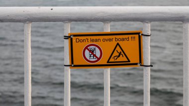 Gemilerdeki metal korkuluklarda grafik simgelerinin olduğu uyarı işareti! Fehmarn, Almanya - 27 Kasım 2022.