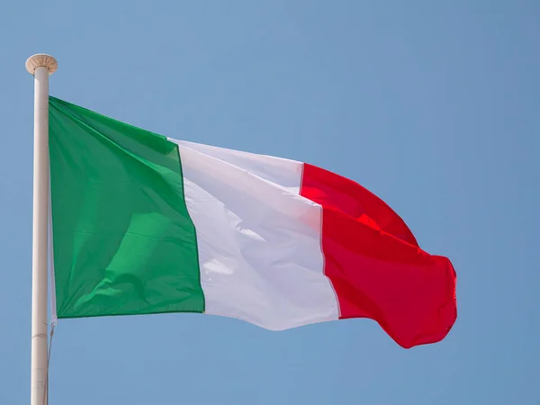 イタリア青い空の背景を持つ旗竿に風に揺れるイタリアの国旗 — ストック写真