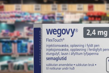 Packaging box of Wegovy (semaglutide) injectable prescription medication, weight-loss drug from Novo Nordisk A/S. Blurred shop shelves in background. Copenhagen, Denmark - August 14, 2023. clipart