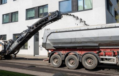 Yol tamirinde asfalt öğütme ve öğütme makinesi. Ağır makine teçhizatıyla sokak yenileme.