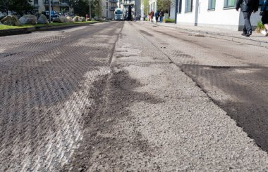 Yol onarımı için asfalt değirmenciliği ve öğütücü kazıma makinesi tarafından hazırlanmış hasarlı yol. Ağır makine teçhizatıyla sokak yenileme.