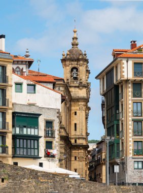 San Sebastian, İspanya 'daki Basilica de Nuestra Senora del Coro Kilisesi' nin önünde binalar bulunan kulesi..