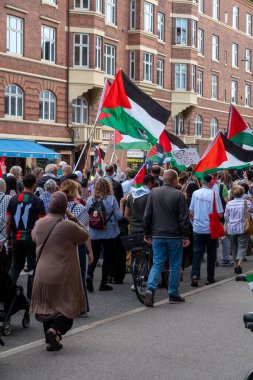 Filistin 'le dayanışmalarını ve Filistin bayraklarıyla el sallamalarını göstermek için gösteri yapan bir grup insan. Kopenhag, Danimarka - 27 Temmuz 2024.